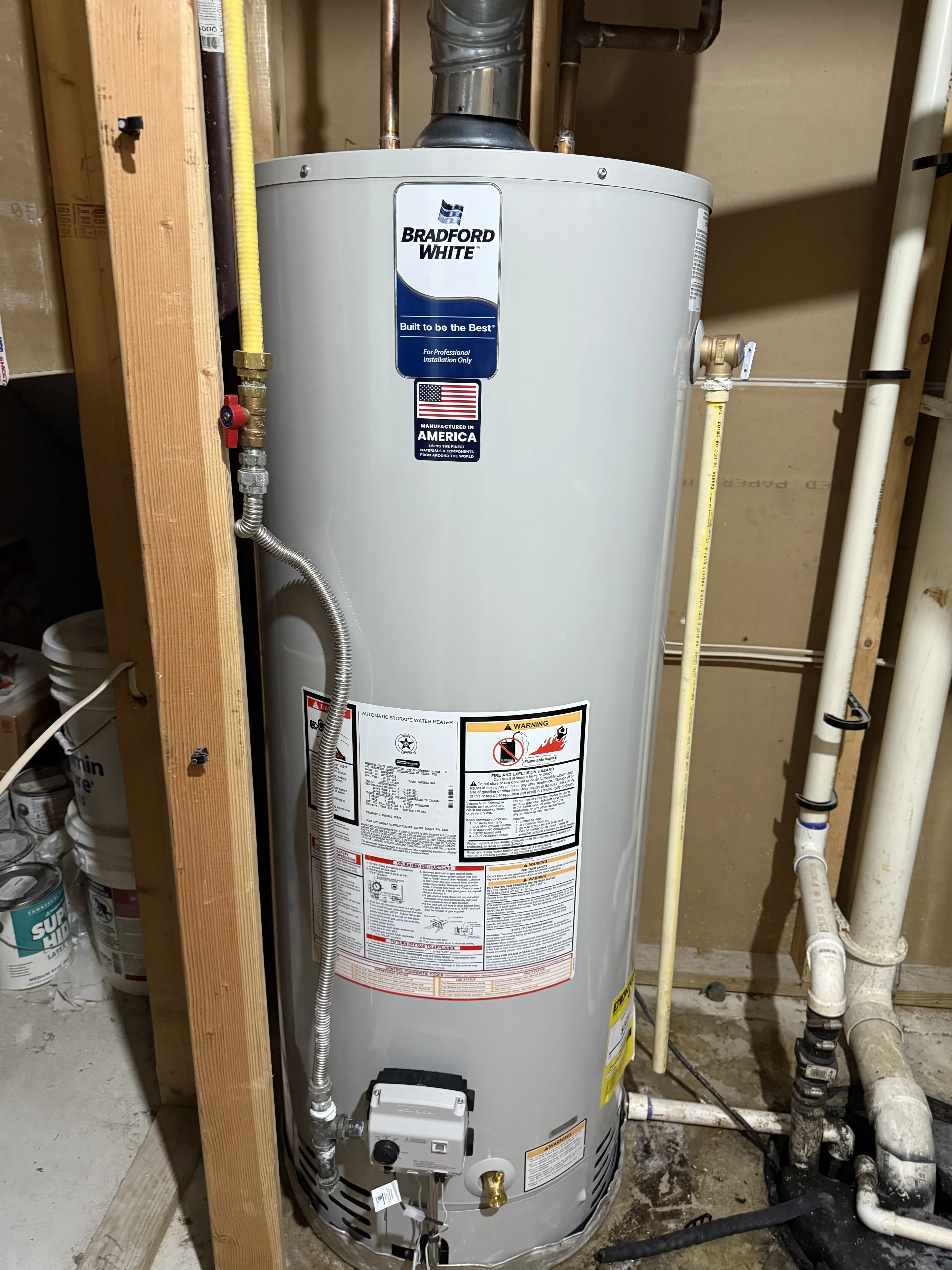 Bradford White gas water heater installed with copper piping, PVC venting, and shut-off valves