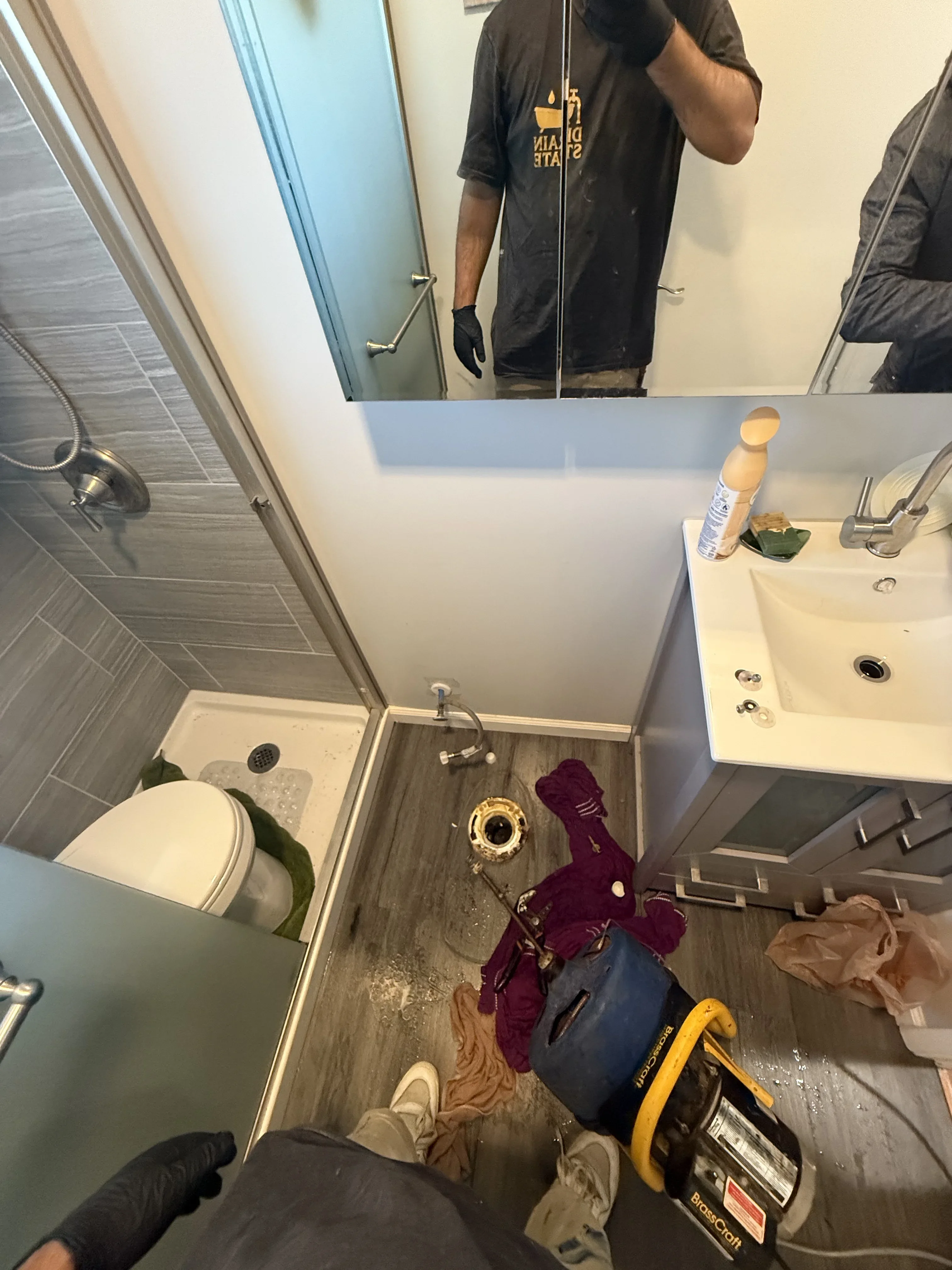 Bathroom with white sink, chrome faucet, white toilet, and gray tile flooring during installation